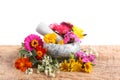 Marble mortar, pestle and different flowers on wooden table against white background Royalty Free Stock Photo