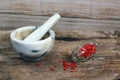 Marble mortar and pestle on old wooden table. Small glass jar wi Royalty Free Stock Photo