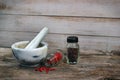 Marble mortar and pestle on old wooden table. Small glass jars w Royalty Free Stock Photo