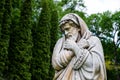 Marble park sculpture of an old man freezing and wrapped into coverlets personifying the cold season of the year. The palace and p