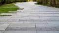 Marble path paved with stone and square tiles. The pedestrian path is paved with paving stones. Grass grows between the tiles. Royalty Free Stock Photo