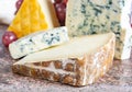 Marble plate with Blue Auvergne AOP French blue cheese, yellow Saint Paulin and Ossau-Iraty sheep cheese, France cheeses served as Royalty Free Stock Photo