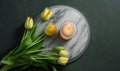 a marble plate with a candle and yellow tulips