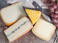 Marble plate with sheep milk cheeses Pur Brebis and Ossau-Iraty from Pyrenees, yellow Saint Paulin and Morbier cow milk cheeses, Royalty Free Stock Photo