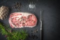 Marble ribeye steak, pepper, larch branch and fork on blue-black slate