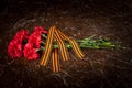 On the marble slab of the monument, is a bouquet of carnations and St. George ribbon