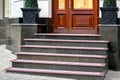 Marble staircase with granite steps to wooden entrance door. Royalty Free Stock Photo