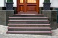 Marble staircase with granite steps to wooden entrance door.