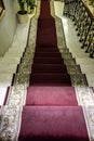 Marble staircase with a red carpet leading up