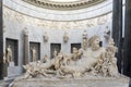 A marble statue of a naked man lying in water and surrounded by many cherubs in one of the museums in Vatican City, Rome