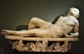 Marble statue of a partially lying man in the Uffizi museum in Florence.