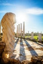 Marble statue under the sun rays and ancient columns at Salamis, Greek and Roman archaeological site, Famagusta, North Cyprus Royalty Free Stock Photo