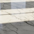 Marble surface with a polished finish featuring natural, dark veining. Sunlight casts so Royalty Free Stock Photo