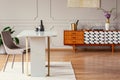 Marble table next to a chair in an eclectic dining room with a retro cabinet