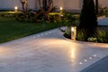 Marble tile playground in the backyard of flowerbeds and lawn with ground lantern.