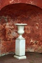 Marble vase on backdrop of defaced ancient wall Royalty Free Stock Photo