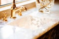 Marble washbasin with mother of pearl finish and gold tap