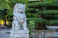 Marble white lion statue in outdoors park in tropical garden, Vietnam Royalty Free Stock Photo