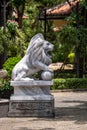 Marble white lion statue in outdoors park in tropical garden, Vietnam