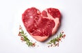 marbled beef steak like heart shape and rosemary hearb isolated on white background