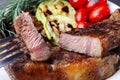 Marbled beef steak with a slice, on a plate with vegetables