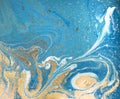 Marbled blue abstract background with golden sequins. Liquid marble ink pattern.