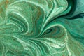 Marbled green abstract background with golden sequins. Liquid marble ink pattern. Royalty Free Stock Photo