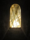 Old marbled window pane artwork in crypt against sunlight Royalty Free Stock Photo