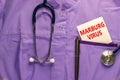 Marburg virus symbol. Medical uniform, white card with words Marburg virus, metalic pen and stethoscope. Medical, marburg virus