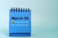 March 20 as International Day of Happiness date reminder on blue desk calendar. Celebration concept.