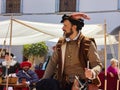 A young dark-haired spanish man in a medieval aristocratic costume and a hat...