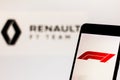 Official F1 FIA Formula 1 logo on the mobile device screen. Team Renault F1 Team logo on background Royalty Free Stock Photo