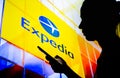 March, 30 2022, Brazil. In this photo illustration, a woman`s silhouette holds a smartphone with the Expedia logo in the Royalty Free Stock Photo
