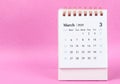 A March 2023 desk calendar on pink color background