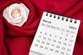 March 2024 desk calendar and pink rose on red textile Royalty Free Stock Photo