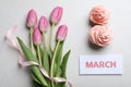 8 March greeting card design with tulips and cupcakes on light grey background, flat lay. International Women`s day Royalty Free Stock Photo