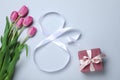 8 March greeting card design with tulips, ribbon and gift box on light grey background, flat lay. International Women`s day Royalty Free Stock Photo