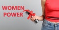 8 March greeting card. Phrase Women Power and young girl holding dumbbell on light background, closeup