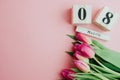 8 March Happy Women`s Day concept. With wooden block calendar and pink tulips on pink background. Copy space