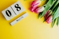 8 March Happy Women`s Day concept. With wooden block calendar and pink tulips on yellow background. Copy space Royalty Free Stock Photo