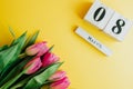 8 March Happy Women`s Day concept. With wooden block calendar and pink tulips on yellow background. Copy space Royalty Free Stock Photo