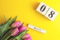 8 March Happy Women`s Day concept. With wooden block calendar and pink tulips on yellow background. Copy space Royalty Free Stock Photo