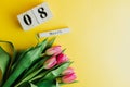 8 March Happy Women`s Day concept. With wooden block calendar and pink tulips on yellow background. Copy space Royalty Free Stock Photo