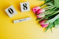 8 March Happy Women`s Day concept. With wooden block calendar and pink tulips on yellow background. Copy space Royalty Free Stock Photo