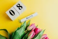 8 March Happy Women`s Day concept. With wooden block calendar and pink tulips on yellow background. Copy space Royalty Free Stock Photo