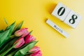 8 March Happy Women`s Day concept. With wooden block calendar and pink tulips on yellow background. Copy space Royalty Free Stock Photo