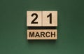 21 march inscription on wooden calendar on green background
