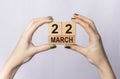 22 March inscription on wooden cubes in female hands