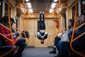 04 of march 2020, Kiev, Ukraine, Subway carrage on the Syrets station. Girl hanging by feet upside down in the subway