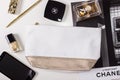 12 March 2018, Moscow - Close up of white cosmetic bag with makeup stuff scattered on table